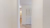 Located at 12017 Salon Drive in Orlando, Florida, this single-story home offers a clean, bright, and functional layout throughout. The interior is finished with neutral white walls and a consistent design language that creates a cohesive and airy atmosphere across all areas.

The bedrooms are carpeted in a neutral tone, providing a comfortable underfoot feel, and each room benefits from good natural light. One bedroom features a window overlooking the exterior, allowing sunlight to fill the space. The rooms offer a blank canvas well-suited for a variety of furniture arrangements.

The hallway and common areas are finished with durable stone-look tile flooring, which flows seamlessly between spaces. A standout feature of the hallway is a set of full-length louvered bi-fold closet doors, offering generous storage while maintaining the home's clean aesthetic. Structural column detailing in the hallway adds a subtle architectural element to the transitional spaces.

The bathroom is finished with white square wall tiles surrounding a full-sized soaking tub and shower combination. Matching tile flooring, a toilet, and classic fixtures complete the space in a tidy, functional manner.

The overall floorplan, visible in the dollhouse view, reflects a compact yet efficient layout with well-defined rooms and easy connectivity between living, sleeping, and bathing areas.