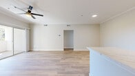 Located in Rancho Cucamonga, CA, this well-appointed 2-bedroom, 2-bathroom residence offers a clean, modern aesthetic with thoughtful finishes throughout. The open-concept living room is anchored by a classic fireplace, warm wood-look luxury vinyl plank flooring, crown molding, and a ceiling fan, with sliding glass doors leading to a private balcony that brings in abundant natural light and outdoor views. The kitchen is a standout, featuring white shaker cabinetry, sleek stone countertops, a peninsula with additional counter space, and a full suite of stainless steel appliances including a refrigerator, range, microwave, and dishwasher. A dedicated hallway area includes additional white cabinetry with stone counters, ideal for added storage or a workspace. Both bedrooms are carpeted and generously sized, with large windows fitted with blinds that invite natural light while maintaining privacy. The primary bedroom includes a walk-in closet with wire shelving. Both bathrooms are finished with white cabinetry, stone-look vanity tops, brushed nickel hardware, and tub-shower combinations with tile surrounds and wood-look flooring. The layout flows efficiently with a central hallway, two closets, and a staircase completing the well-organized floor plan.