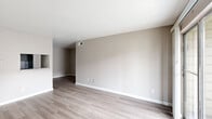 Located at 7500 Bellerive Dr in Houston, TX, this single-floor 2-bedroom, 1-bathroom home offers a practical and comfortable layout. Light wood-style flooring runs consistently throughout, lending a clean and cohesive look to every room. The living room is bright and open, featuring neutral warm-toned walls and a sliding glass door that leads to an outdoor patio, filling the space with natural light. Adjacent to the living area, the dining room flows naturally into the kitchen, which features a pass-through granite-topped counter — a functional detail that connects the two spaces. A pantry provides additional storage conveniently near the kitchen. Both bedrooms are well-proportioned, each equipped with ceiling fans with light fixtures and window blinds for natural light control. The primary bedroom includes a spacious walk-in closet with built-in shelving, while the second bedroom features a sliding panel closet. Three closets total are distributed throughout the unit. The bathroom includes a granite-topped vanity with under-cabinet storage, a mirrored medicine cabinet, and a full bathtub with tiled surround. A hallway connects the main living areas to the bedrooms, completing this efficiently designed single-story home.