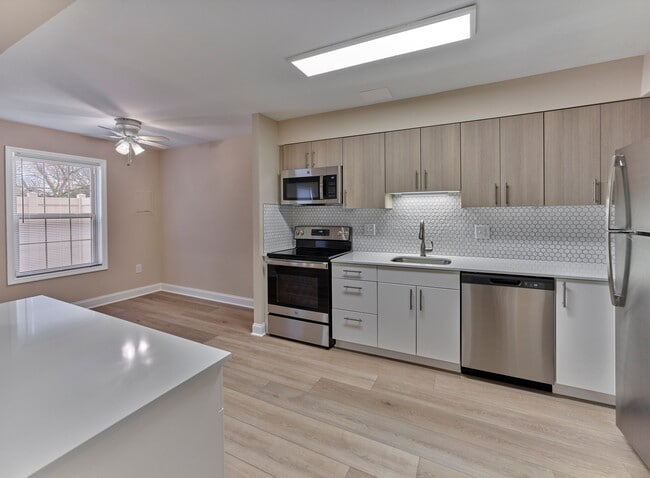 Descubra los acabados de cocina de diseño que pronto estarán disponibles en North Crossing Apartments, con electrodomésticos de acero inoxidable, encimeras de cuarzo y gabinetes contemporáneos, como se muestra aquí en nuestra comunidad hermana, Woods Edge. - North Crossing