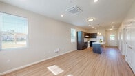 Located at 1330 N Fourth St in Terre Haute, Indiana, this well-designed single-story home offers two bedrooms, two bathrooms, and a thoughtfully organized layout that maximizes functionality. Light wood-style flooring runs throughout the entire space, complementing the neutral, warm-toned walls and creating a cohesive, modern aesthetic.

The open-concept living and kitchen area serves as the heart of the home. The kitchen features dark espresso-toned cabinetry accented by blue lower cabinets, a light countertop island with a built-in sink, pendant lighting, recessed ceiling lights, and white appliances. The living area benefits from natural light through a window and offers ample room for flexible furniture arrangements.

Both bedrooms are bright and airy, with multiple windows inviting generous natural light and views of the surrounding neighborhood. Each bedroom includes closet space, with at least one closet featuring a built-in rod and shelving system. The primary bedroom is comfortably sized with room for a full bedroom suite.

The two bathrooms are clean and contemporary, each equipped with dark vanity cabinetry, white countertops, and large mirrors. One bathroom includes a full soaking tub with a shower. A dedicated utility room and three total closets round out the practical offerings of this well-appointed home.