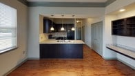 Located at 435 Langtree Rd in Mooresville, NC, this single-floor residence offers a thoughtfully designed layout with a seamless blend of style and functionality. The open-concept living and dining area is anchored by rich hardwood-style flooring and accented with crown molding and a ceiling fan, while multiple windows flood the space with natural light. The kitchen features dark espresso cabinetry, granite countertops, a tile backsplash, black appliances including a range and built-in microwave, and a peninsula with pendant lighting and a stainless steel sink — ideal for both cooking and entertaining. The bedrooms are carpeted and include ceiling fans; one bedroom opens directly onto a private balcony with outdoor views of lush greenery. The primary bathroom is well-appointed with dark cabinetry, granite countertops, hardwood-style flooring, a tiled walk-in shower, and access to a walk-in closet. A second full bathroom mirrors the same quality finishes, offering a tiled shower-tub combination. The overall ambiance is clean, modern, and move-in ready, with consistent design elements tying each space together cohesively.