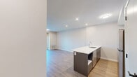Located at 1100 Afton Dr in Windsor, Ontario, this well-appointed one-bedroom, one-bathroom unit offers a thoughtfully designed layout across a single floor. The open-concept kitchen and living area serves as the heart of the space, featuring a striking blue kitchen island with a white quartz countertop, white shaker-style cabinetry, stainless steel appliances including a refrigerator and electric range, and recessed lighting overhead. Warm, light-toned hardwood-style flooring flows consistently throughout every room, creating a cohesive and inviting atmosphere. The living area is bright and airy, with a sliding glass door that opens to a balcony, allowing natural light to fill the space and providing views of the surrounding neighbourhood. The bedroom is a comfortable, well-proportioned room featuring a large window that brings in additional natural light and outdoor views, along with a sliding closet door for practical storage. The bathroom is finished in a clean, modern style with white shaker vanity cabinetry, a white quartz countertop, a full bathtub and shower combo, and consistent hardwood-style flooring. Neutral, warm-toned walls throughout the unit contribute to a calm and contemporary ambiance, making this a functional and stylish space.