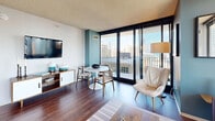 Located in Chicago's vibrant Lakeshore East neighborhood, this one-bedroom, one-bathroom residence offers a well-designed layout with an open-concept living and dining area at its heart. Floor-to-ceiling sliding glass doors flood the living space with natural light and frame stunning views of the Chicago skyline and surrounding greenery, leading directly to a private balcony — an ideal vantage point for taking in the city. Dark hardwood flooring anchors the living area, which features a bold accent wall and modern finishes throughout. The kitchen is efficiently appointed and flows seamlessly into the dining and living spaces. The generously sized bedroom continues the city-view theme, with large floor-to-ceiling windows, plush carpeting, and a striking teal accent wall that adds a pop of color and personality. Multiple closets provide ample storage throughout the residence. The bathroom is finished with tile surround and a full tub/shower combination. A dedicated laundry area adds everyday convenience. A welcoming hallway connects all rooms with a clean, functional aesthetic. This residence offers a compelling blend of urban views, modern design, and practical amenities in one of Chicago's most desirable neighborhoods.