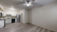 This one-bedroom, one-bathroom unit at 1325 W Tharpe St in Tallahassee, Florida offers a thoughtfully laid-out, single-floor living space. The open-concept living and dining area features light-toned hardwood-style flooring and a ceiling fan with integrated lighting, creating a bright and airy atmosphere. The kitchen is well-appointed with white shaker-style cabinetry, granite-look countertops, and a full suite of appliances including a stainless steel refrigerator, black electric range, built-in microwave, and dishwasher. A dedicated laundry area includes an in-unit washer and dryer, adding everyday convenience. The bedroom is a cozy, carpeted retreat with a ceiling fan, natural light from a window with blinds overlooking greenery, and access to a closet. The bathroom is cleanly finished with a white vanity, oval mirror, and a tub/shower combination. Neutral tones and clean finishes are carried throughout the unit, providing a cohesive and move-in ready aesthetic. The overall design prioritizes functionality and comfort, making this a practical and well-equipped living space in Tallahassee.