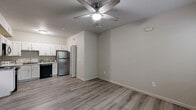This one-bedroom, one-bathroom unit at 1325 W Tharpe St in Tallahassee, Florida offers a thoughtfully laid-out, single-floor living space. The open-concept living and dining area features light-toned hardwood-style flooring and a ceiling fan with integrated lighting, creating a bright and airy atmosphere. The kitchen is well-appointed with white shaker-style cabinetry, granite-look countertops, and a full suite of appliances including a stainless steel refrigerator, black electric range, built-in microwave, and dishwasher. A dedicated laundry area includes an in-unit washer and dryer, adding everyday convenience. The bedroom is a cozy, carpeted retreat with a ceiling fan, natural light from a window with blinds overlooking greenery, and access to a closet. The bathroom is cleanly finished with a white vanity, oval mirror, and a tub/shower combination. Neutral tones and clean finishes are carried throughout the unit, providing a cohesive and move-in ready aesthetic. The overall design prioritizes functionality and comfort, making this a practical and well-equipped living space in Tallahassee.