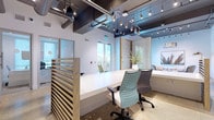 This single-floor office space combines open-plan and private work environments in a thoughtfully designed layout. The central workspace features long white bench-style desks paired with ergonomic chairs, divided by slatted natural wood partitions that provide subtle separation while maintaining an open feel. Exposed ductwork and dark ceiling beams contrast against white walls, while pendant and track lighting illuminate the space with a modern industrial touch. Large doors allow natural light to filter through, enhancing the bright, airy atmosphere.

Private offices line the perimeter, enclosed by full-height glass walls and doors, offering visual transparency while ensuring acoustic privacy. Each office is equipped with a desk and ergonomic seating, making them well-suited for focused, individual work.

A dedicated lounge area provides a comfortable retreat, furnished with neutral upholstered armchairs, a round wood coffee table, and warm accent lighting from a gold-toned floor lamp. A large botanical wall print adds a relaxed, coastal character to the space.

A hallway connects the main areas to additional rooms and a functional kitchenette, which includes ample cabinetry, a dark stone countertop, stainless steel appliances, and space for office equipment such as a printer.