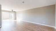 Located at 319 Imperial Beach Boulevard in Imperial Beach, CA, this two-story home offers four bedrooms and two bathrooms across a well-organized layout. The ground floor features a bright, open living room with light wood-look flooring, neutral gray walls, a ceiling fan, and a sliding glass door that invites natural light and outdoor access. The adjacent kitchen is equipped with white cabinetry, a gas range, range hood, and a sink with a light stone-style countertop, providing a clean and functional cooking space. A full bathroom on this level features a white vanity with a marble-style countertop, built-in storage cabinetry, and a mirror. The upper floor hosts the bedrooms, each carpeted for comfort and filled with natural light through large windows that offer neighborhood views. The spacious primary bedroom includes a mirrored sliding closet door with built-in shelving. A second well-appointed bathroom upstairs features wood-look flooring, a white vanity with a marble-style countertop, a window for natural light, and ample storage. Clean white trim, neutral tones, and a consistent design palette create a cohesive, move-in ready atmosphere throughout the home.