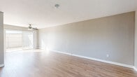 Located at 319 Imperial Beach Boulevard in Imperial Beach, CA, this two-story home offers four bedrooms and two bathrooms across a well-organized layout. The ground floor features a bright, open living room with light wood-look flooring, neutral gray walls, a ceiling fan, and a sliding glass door that invites natural light and outdoor access. The adjacent kitchen is equipped with white cabinetry, a gas range, range hood, and a sink with a light stone-style countertop, providing a clean and functional cooking space. A full bathroom on this level features a white vanity with a marble-style countertop, built-in storage cabinetry, and a mirror. The upper floor hosts the bedrooms, each carpeted for comfort and filled with natural light through large windows that offer neighborhood views. The spacious primary bedroom includes a mirrored sliding closet door with built-in shelving. A second well-appointed bathroom upstairs features wood-look flooring, a white vanity with a marble-style countertop, a window for natural light, and ample storage. Clean white trim, neutral tones, and a consistent design palette create a cohesive, move-in ready atmosphere throughout the home.