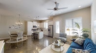 This single-story home offers a thoughtfully designed open-concept layout across three bedrooms and two bathrooms. Polished concrete floors run throughout the main living areas, providing a sleek, low-maintenance foundation that ties the spaces together cohesively.

The heart of the home is the kitchen, which features white shaker-style cabinetry extending to the ceiling, granite countertops, stainless steel appliances, and a central island with bar seating. Pendant lighting illuminates the island, while recessed lighting brightens the entire space. The kitchen flows seamlessly into the dining area, which is anchored by an elegant chandelier, and into the living room, where a ceiling fan and natural light from multiple windows create a comfortable atmosphere.

One of the three bedrooms functions as a flexible home office, featuring a window that fills the room with natural light. The primary bedroom is finished in soft, calming tones and includes a barn-style sliding door. The primary bathroom offers a long granite vanity with white cabinetry and a walk-in closet. The second bathroom is compact and efficiently designed with a granite-topped vanity and shower-tub combination. The overall ambiance is clean, modern, and move-in ready.