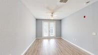 Located at 940 W Canton Ave in Winter Park, FL, this two-bedroom, one-bathroom residence offers a well-designed single-floor layout that balances comfort and functionality. Light wood-style flooring flows throughout the main living areas, complemented by soft gray walls and crisp white trim that create a clean, modern aesthetic. Ceiling fans are featured throughout, promoting airflow and comfort.

The open kitchen is a standout feature, showcasing rich dark wood cabinetry, granite countertops, a white subway tile backsplash, and a full suite of stainless steel appliances including a refrigerator, range, microwave, and dishwasher. Track lighting illuminates the space, and the layout allows for easy connection to the adjacent living area.

The living room is bright and airy, highlighted by French doors that invite natural light and provide outdoor access. A dedicated hallway with louvered closet doors offers ample storage. The bedrooms feature plush carpeting and ceiling fans; the secondary bedroom benefits from large windows with views of the surrounding Winter Park area. The bathroom is finished with a granite-topped dark wood vanity, tile flooring, and a large mirror. A carpeted hallway connects the private and shared spaces seamlessly.
