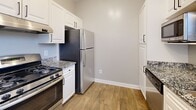 This single-floor, 2-bedroom, 2-bathroom home offers a thoughtfully designed layout that maximizes comfort and functionality. The living and dining areas are bright and inviting, featuring warm hardwood-style flooring, crown molding, and large windows fitted with blinds that frame lush outdoor greenery. The dining room is particularly well-lit, benefiting from multiple windows that flood the space with natural light.

The kitchen is efficiently designed with crisp white cabinetry, granite-look countertops, stainless steel appliances including a gas range and refrigerator, and durable wood-style flooring — offering a clean, modern aesthetic.

Both bedrooms are carpeted and comfortably sized, with the primary bedroom featuring a closet and a private exterior door. Ceiling fans are present in the bedrooms, enhancing ventilation and comfort. The second bedroom offers a window view of the outdoors and ample wall space.

The two bathrooms are finished with wood-style flooring, white vanities topped with granite-look countertops, and tiled tub-shower combinations. One bathroom features a distinctive green tile accent border, adding a touch of character to the otherwise neutral palette.

A hallway and closet complete the floor plan, ensuring practical storage throughout. Neutral gray tones and white trim carry a cohesive, clean look across all rooms.