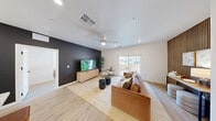 Located at 2555 N Rancho Dr in Las Vegas, NV, this thoughtfully designed 2-bedroom, 2-bathroom unit offers a contemporary living experience across a single floor. Light wood-look flooring flows throughout, complementing the clean white walls and black hardware accents visible from the welcoming entryway hallway.

The open-concept kitchen is a standout feature, showcasing floor-to-ceiling white shaker cabinetry, quartz countertops, a full suite of stainless steel appliances, and a central island with bar seating — ideal for both cooking and casual dining. An in-unit washer and dryer closet adds everyday convenience.

The living room is anchored by a striking black accent wall on one side and a warm wood slat feature wall on the other, creating a dynamic, design-forward atmosphere. A ceiling fan, recessed lighting, and sliding glass doors opening to a private patio enhance both comfort and natural light.

The primary bedroom features a bold terracotta-toned accent wall and a ceiling fan, while the second bedroom is bright and airy with large windows. Both bathrooms are finished with clean, modern fixtures, including a sliding glass-door shower. Two dedicated closets provide ample storage throughout the home.