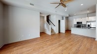 This two-story home is thoughtfully designed with a consistent aesthetic carried throughout both levels. Warm hardwood-style flooring runs through the main living areas, bedrooms, and hallways, lending a cohesive and inviting character to the entire space. The main level opens into a spacious living area illuminated by recessed lighting and equipped with a ceiling fan. A staircase with white-painted railings connects the two floors, and multiple doors provide access to additional rooms and storage areas.

The kitchen is well-appointed with crisp white shaker-style cabinetry extending to the ceiling for ample storage, dark granite countertops with natural veining, a matching granite tile backsplash, and a full suite of stainless steel appliances including a range, over-the-range microwave, and refrigerator with an ice and water dispenser.

The upper level hosts several bedrooms, each featuring ceiling fans with integrated lighting and windows dressed with white blinds that allow for natural light. At least one bedroom includes an adjacent walk-in closet and direct access to a bathroom. The bathrooms are finished with white cabinetry, granite countertops, and soaking tubs surrounded by floor-to-ceiling marble-toned hexagonal mosaic tile, adding a refined decorative touch.