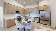Located at 398 West Valley Boulevard in San Gabriel, CA, this well-appointed 2-bedroom, 2-bathroom residence offers a thoughtfully designed single-floor layout with a clean, modern aesthetic. Light wood-tone flooring flows throughout the main living spaces, complemented by neutral wall tones and recessed lighting that create a bright, welcoming ambiance.

The open-concept kitchen is a standout feature, showcasing warm wood cabinetry extending to the ceiling, white quartz countertops, a full suite of stainless steel appliances including a gas range, microwave, dishwasher, and French door refrigerator, and a stainless undermount sink. A dining area sits within the kitchen space, ideal for everyday meals.

The living room offers generous wall-mounted TV placement, high ceilings, and direct access to the private balcony, allowing natural light to filter in through glass-paneled entry doors.

The primary bedroom is a comfortable retreat with plush carpeting, dual nightstand lighting, a closet, and a window with outdoor views. The second bedroom also features carpeted flooring and a window with exterior views. Both bathrooms are finished in a crisp, neutral palette — one featuring a sliding glass door tub-shower combo with a wood-toned vanity, and the other a tub-shower with a chrome grab bar and wood-look flooring.