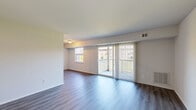 Located at 5739 Hazelwood Cir in Baltimore, MD, this three-bedroom, one-bathroom residence offers a practical and comfortable layout across a single floor. The living room is a bright, open space highlighted by dark hardwood-style flooring, a sliding glass door, and an adjacent window that together flood the room with natural light and provide direct access to a private balcony with outdoor views. The kitchen is well-equipped with light wood cabinetry, granite-style countertops, a black range, and a built-in breakfast bar peninsula that connects seamlessly to the living area. The primary bedroom is a comfortable size, while all three bedrooms feature soft carpeting and neutral wall tones. Closets with built-in hanging rods provide practical storage in the bedrooms. The hallway connects the main living areas efficiently, contributing to the home's straightforward and navigable floor plan. The full bathroom includes a tiled tub-shower combination with chrome fixtures, maintaining a clean and classic aesthetic throughout. Overall, the space presents a clean, move-in-ready interior with consistent neutral finishes and ample natural light.