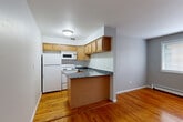 Located at 6040 N Sheridan Road in Chicago's Edgewater neighborhood, this single-floor unit offers an efficient and well-organized layout. Warm-toned hardwood floors run throughout the space, lending a cohesive and inviting feel to every room.

The combined living and dining area is open and practical, featuring soft gray walls and a window that allows natural light to filter in. A window air conditioning unit and baseboard heating provide year-round climate control. Two closets off the hallway offer ample storage for a space of this size.

The kitchen is a functional standout, featuring warm wood cabinetry that extends to the ceiling for maximum storage, dark granite countertops with subtle veining, a peninsula that opens toward the living area, a double stainless steel sink, and white appliances including a refrigerator, electric range, and built-in microwave.

The bathroom is clean and well-appointed, with white square tile in the shower/tub surround, classic mosaic tile flooring, a wood vanity with storage, and a full bathtub. A hallway connects all rooms, keeping the layout organized and easy to navigate. This unit provides a practical and comfortable living environment in a prime Chicago lakeside neighborhood.