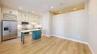 This thoughtfully designed one-bedroom, one-bathroom unit in Decatur, GA offers a functional and stylish layout across a single floor. The open-concept kitchen and living area serves as the heart of the home, featuring light hardwood-style flooring, recessed lighting, and a seamless flow throughout. The kitchen is a standout, equipped with floor-to-ceiling white shaker cabinetry, matte black hardware, stainless steel appliances including a range, microwave, and refrigerator, and a striking teal island with a white quartz countertop that adds a bold pop of color. Natural light fills the space through multiple windows with horizontal blinds, and a glass-paneled door provides additional brightness and outdoor access. The bedroom offers plush carpeting, neutral warm-toned walls, a ceiling fan, and direct access to a generously sized walk-in closet outfitted with double hanging rods and shelving on multiple walls. The bathroom is finished with elegant marble-look tile covering both the floors and the tub surround, complemented by chrome fixtures and a soaking tub with shower. Clean lines, contemporary finishes, and a cohesive neutral palette give this unit a fresh, modern character throughout.