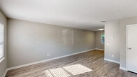 Located at 7229 Tama Rd in Columbia, SC, this two-story home offers a practical and well-organized layout split evenly across both floors. The main level features an open living room bathed in natural light through a window, showcasing durable wood-look plank flooring and neutral gray walls with clean white baseboards. The adjacent kitchen is efficiently designed with white cabinetry, a classic subway tile backsplash, black appliances including a range, dishwasher, and refrigerator, and a stainless steel sink. Upstairs, two bedrooms provide comfortable accommodations, each carpeted and equipped with ceiling fans and windows offering views of surrounding greenery. The spacious primary bedroom features two windows and a dedicated closet, while the second bedroom includes its own closet with double doors. Both bathrooms are finished with wood-look flooring and neutral tones; one features a tub-shower combo with white tile surround and a granite-top vanity, while the second offers a wall-mounted heater unit. Textured ceilings are present throughout, and the home's consistent use of gray tones, white trim, and natural light creates a cohesive, clean aesthetic.