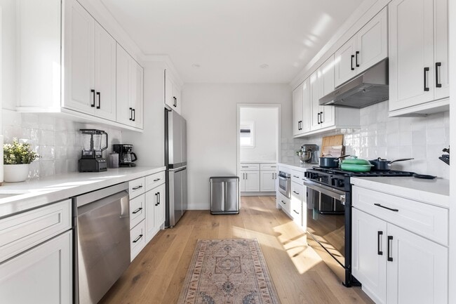 Chef's kitchen with natural sunlight and luxury appliances. - 1823 N Ditman Ave