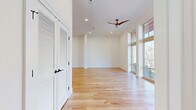 Located at 3215 Stuart Ave in Richmond's desirable 23221 zip code, this thoughtfully designed two-floor residence offers a refined blend of modern architecture and quality craftsmanship. Light hardwood flooring flows throughout both levels, complemented by crisp white walls and recessed lighting that create a bright, airy atmosphere.

The main floor hosts a spacious living room and kitchen combination, where floor-to-ceiling windows bathe the space in natural light and provide open views of the surrounding neighborhood. The gourmet kitchen stands out with sleek white cabinetry accented by gold hardware, striking marbled granite countertops and backsplash, and stainless steel appliances. A dedicated laundry room with tile flooring and built-in shelving adds everyday convenience.

Upstairs, the generously sized bedroom features a dramatic arched window alongside additional windows, flooding the room with light and framing treetop views. A spacious walk-in closet with built-in shelving provides ample storage. The home includes four well-appointed bathrooms, one of which showcases geometric patterned tile flooring, warm wood vanity cabinetry, and gold fixtures. Three closets and two hallways complete the thoughtful layout, making this residence as functional as it is stylish.