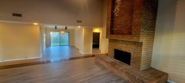 Living room with brick fireplace and dining room - 16139 Ladera Piedra Way