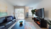 This single-story residence offers a well-organized layout designed for comfortable everyday living. The living room serves as the central gathering space, featuring plush carpeting, a sliding glass door that opens to an outdoor balcony, and a side window that brings in natural light and outdoor views. A dedicated dining area sits adjacent, providing a seamless transition between spaces.

The kitchen is equipped with white cabinetry, warm-toned countertops, a dishwasher, and tile flooring. A peninsula with seating for two serves as both a functional workspace and a casual dining spot, illuminated by pendant lighting overhead.

The unit includes multiple carpeted bedrooms, each featuring windows that allow natural light to filter in. One bedroom includes a mirrored sliding closet, enhancing the sense of space. The remaining bedrooms offer clean, neutral interiors with ample room for furnishings.

Two bathrooms serve the unit: one features a double-sink vanity with a wide mirror and tile flooring, while the second offers a single-sink vanity with white cabinetry and a tub-shower combination. Both maintain a consistent, clean aesthetic throughout.
