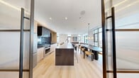 Located at 422 Cherry Street in Toronto's vibrant waterfront community, this single-floor amenity space offers a thoughtfully designed layout that seamlessly blends social and recreational areas. The space is bathed in natural light, courtesy of floor-to-ceiling windows that frame impressive panoramic views of the Toronto skyline — a defining architectural feature throughout.

The living and dining area serves as the central gathering space, furnished with rich cognac leather sofas, a woven area rug, and a marble-topped coffee table, all set against light hardwood flooring and crisp white walls. A wooden sideboard and large-scale artwork add warmth and character to the room.

Adjacent to the living area is a welcoming lounge nook near the entrance, featuring retro-inspired armchairs, a round side table, and a bold dome pendant light — ideal for casual seating or a quiet retreat.

The games room is a standout feature, centered around a full-size pool table with a red felt surface, illuminated by a sculptural, looping neon pendant light. High bar tables with leather stools line the perimeter, offering additional seating while overlooking the city views through expansive windows.

Throughout the space, the design aesthetic is consistently modern and refined, combining clean lines, quality materials, and curated artwork to create an elevated, welcoming atmosphere.