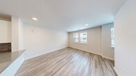 Located in Tomball, TX, this contemporary 3-story townhome offers a well-designed layout across three distinct levels. The ground floor houses an attached garage with a smooth concrete floor, an automatic opener, and an electrical panel, providing convenient and secure parking. A private outdoor patio area features a gravel surface enclosed by a cedar wood fence, offering a low-maintenance outdoor retreat.

The main living level showcases an open-concept kitchen and living area with light wood-look flooring throughout. The kitchen is outfitted with white shaker cabinetry, granite countertops, a gray tile backsplash, stainless steel appliances including a French door refrigerator, and a deep undermount sink — all contributing to a clean, modern aesthetic. The adjacent living area flows naturally from the kitchen, making the space feel connected and functional.

The upper level hosts two carpeted bedrooms, each equipped with ceiling fans. The generously sized primary bedroom includes a walk-in closet with built-in wire shelving. The bathrooms are elegantly appointed with large-format tile flooring, marble-style tiled tub and shower surrounds, white vanity cabinetry with granite countertops, and illuminated mirrors. Neutral tones and modern finishes are carried consistently throughout the home, creating a cohesive and move-in-ready living environment.