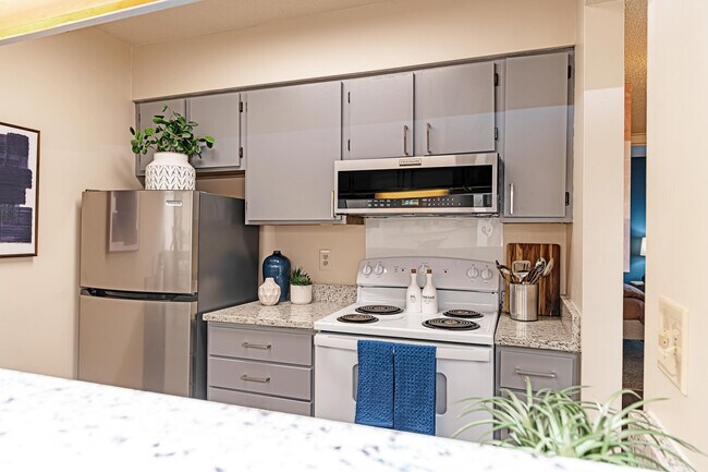 Cocina con encimeras de granito y gabinetes modernos. - The Manning