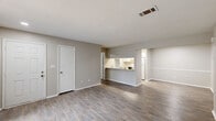 Located at 206 Northlake Dr in Warner Robins, Georgia, this single-floor, 2-bedroom, 2-bathroom home offers a practical and comfortable layout. The open living area features wood-look plank flooring, neutral gray walls, and textured ceilings, creating a clean and inviting atmosphere. A pass-through window connects the living and dining area to the galley-style kitchen, which is equipped with white cabinetry, a refrigerator, electric range, dishwasher, and a stainless steel sink — all set over matching wood-look flooring. A sliding glass door floods the living space with natural light and provides access to the outdoors. Both bedrooms are carpeted and offer a quiet, comfortable feel, with ample closet storage — the home includes five closets in total. The two bathrooms are well-appointed; one features marble-style tile surrounding a full bathtub and shower, while the second offers a tub-shower combo with wood-look flooring and a vanity with storage. Additional practical spaces include a dedicated laundry area, a utility room, and a hallway connecting the main rooms. The layout is efficient and thoughtfully designed, making excellent use of the available space throughout.