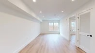 Located in the Capitol Hill neighborhood of Washington, DC, this thoughtfully designed unit at 716 L St SE offers a clean, modern aesthetic throughout its single-floor layout. Light hardwood flooring runs continuously across the living, sleeping, and kitchen areas, creating a warm and cohesive feel.

The open living area is bathed in natural light from multi-pane windows that frame views of the surrounding brick streetscape. Recessed lighting and crisp white walls enhance the bright, airy atmosphere. The layout flows seamlessly into a well-appointed kitchen featuring sleek flat-front cabinetry in a soft neutral tone, a white quartz countertop, a herringbone tile backsplash, and a full suite of stainless steel appliances including a gas range, built-in microwave, French door refrigerator, and dishwasher. A matte black faucet adds a refined contrast at the sink.

The bedroom offers a quiet retreat with its own window providing natural light, complemented by a dedicated walk-in closet with built-in wire shelving for organized storage. The bathroom is finished with floor-to-ceiling tile, a frameless glass-enclosed shower with mosaic tile flooring, and matte black hardware throughout. The unit presents a move-in-ready, freshly constructed interior in a desirable DC neighborhood.