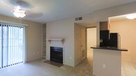 Located at 710 Lindh Rd in Gulfport, Mississippi, this single-floor residence offers a functional and comfortable layout designed for easy living. The living area serves as the heart of the home, anchored by a classic fireplace with a white mantel and a tile hearth, adding warmth and character to the space. Built-in open shelving flanks one side of the fireplace, providing convenient display and storage space. The living area features neutral-toned carpet, creating a soft and inviting atmosphere throughout. A textured ceiling adds subtle architectural detail overhead, while ceiling-mounted HVAC vents ensure year-round climate comfort. The layout flows naturally from the living space toward the kitchen, which is partially visible and features dark countertops, offering a contrast to the light, neutral palette of the rest of the home. A connecting hallway leads to additional areas of the unit, maintaining a cohesive and open feel throughout. The overall ambiance is clean, understated, and practical, making this Gulfport residence a solid option for those seeking a straightforward, move-in ready space on the Mississippi Gulf Coast.