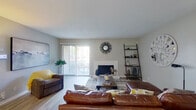 This single-floor residence offers a thoughtfully designed layout encompassing two bedrooms and four bathrooms. The living room serves as the central gathering space, featuring a white-surround fireplace, light wood-style flooring, and a sliding glass door that floods the room with natural light and provides access to an outdoor patio. Decorative ladder shelving adds a modern touch to the neutral-toned walls.

The adjacent dining area includes built-in shelving and a breakfast bar, offering additional storage and casual seating alongside a dedicated dining table space. The galley-style kitchen is efficiently organized with white cabinetry, granite-look countertops, black appliances, and a stainless steel sink, maximizing functionality within a compact footprint.

The primary bedroom provides a comfortable retreat with plush carpeting, a ceiling fan, natural light from dual windows, and generous space for furnishings. The bathrooms are finished with wide vanities, white cabinetry, granite-look countertops, large mirrors, and shower-tub combinations. Additional bathrooms follow the same clean, consistent design aesthetic throughout, ensuring practicality and cohesion across the entire residence.