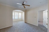 Located at 3378 Greenbriar Pkwy SW in Atlanta, Georgia, this single-floor, 4-bedroom, 3-bathroom home offers a well-organized layout designed for comfortable living. The main living area features plush carpet, crown molding, a ceiling fan, and an elegant arched passageway that leads to a naturally lit nook with large windows overlooking the outdoors. A second ceiling fan and open sightlines to the kitchen enhance the sense of spaciousness throughout the common areas. The kitchen is equipped with warm wood cabinetry, tile backsplash, light countertops, black appliances including an electric range and over-the-range microwave, and a breakfast bar with a pendant light overhead. Light tile flooring carries through the kitchen and bathrooms, providing a clean contrast to the carpeted living spaces. The primary bedroom is a generous retreat with ample room for furnishings. The three bathrooms are finished with tile flooring, wood-toned vanities, and bright lighting fixtures — one featuring a full tub/shower combination. Bedrooms throughout are bright, with large windows allowing natural light. The dedicated laundry room houses a full-size washer and dryer, and two closets provide additional storage. Hallways connect the rooms efficiently, completing this practical and cohesive floor plan.