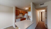 Located at 5620 Fox Horn Cir in Louisville, KY, this single-floor residence offers a practical and comfortable layout designed for everyday living. The kitchen is well-equipped with warm honey-toned oak cabinetry, ample upper and lower storage, light countertops, and a full suite of white appliances including a refrigerator, electric range, dishwasher, and built-in microwave. Tile flooring runs throughout the kitchen, which opens to the living area via a convenient breakfast bar peninsula — ideal for casual dining or entertaining. The spacious living room features plush carpeting, neutral warm-toned walls, a ceiling fan, and a textured ceiling, creating a relaxed and inviting atmosphere. A hallway connects the living spaces to the bedrooms, each of which is carpeted and filled with natural light through blinded windows. Ceiling fans are featured in the bedrooms for added comfort. The unit includes two full bathrooms, each with a tub/shower combination and tile flooring. One bathroom features a large vanity mirror with bright overhead lighting and convenient access to the in-unit stacked washer and dryer. Throughout the home, white six-panel doors and clean white trim complement the neutral color palette, giving the space a cohesive and well-maintained appearance.