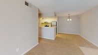 This single-floor residence at 222 Old Fayetteville Rd in Carrboro, NC offers a well-organized layout designed for comfortable everyday living. The open-concept living and dining area is anchored by a classic fireplace with a white mantel, plush wall-to-wall carpeting, and a ceiling fan overhead. A sliding glass door allows natural light to fill the space and provides access to the outdoors.

The kitchen is positioned behind a raised peninsula counter that separates it from the main living area. It features white cabinetry, light countertops, a stainless steel refrigerator, an electric range, and a built-in dishwasher. Track lighting illuminates the workspace efficiently, while a decorative pendant chandelier adds a touch of warmth to the adjacent dining zone. The kitchen area transitions to hardwood-style flooring, creating a practical contrast to the carpeted living spaces.

The bedroom is a generously sized, quiet retreat with soft carpeting and a large window fitted with horizontal blinds, allowing for ample natural light and a view of the surrounding greenery. Neutral wall tones throughout the unit contribute to a calm and cohesive aesthetic.

The bathroom includes a full tub-and-shower combination with chrome fixtures and a classic checkered tile border accent, complemented by a vanity with a light countertop. The space is clean, functional, and well-appointed.