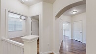 Located in Katy, TX (77450), this two-bedroom, two-bathroom two-story home offers a thoughtfully designed layout spread across two floors. The ground level houses an attached garage with an automatic opener, providing convenient vehicle storage. The main living floor features an open-concept kitchen and living area anchored by rich hardwood-style flooring throughout. The kitchen is well-appointed with dark espresso cabinetry, granite countertops, a tile backsplash, stainless steel appliances including a French door refrigerator with ice maker, electric range, and built-in microwave, plus a peninsula with pendant lighting. The living area benefits from crown molding and a ceiling fan. A dedicated laundry room with washer and dryer hookups and additional shelving adds everyday convenience. Both bedrooms are carpeted and feature ceiling fans and natural light from windows with blinds. The generously sized primary bedroom includes a walk-in closet with dual hanging rods. The bathrooms feature granite-topped dark vanities, wood-look tile flooring, and a full tub-shower combination with white subway tile surround. Each bedroom is served by its own closet, offering ample storage throughout the home.