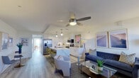 This well-designed single-floor residence offers a seamless open-concept layout that connects the living, dining, and kitchen areas into one cohesive and functional space. The kitchen is a standout feature, boasting crisp white cabinetry that extends to the ceiling, quartz marble-look countertops, stainless steel appliances including a French door refrigerator and range, a built-in microwave, and a central island with bar seating — ideal for casual dining or entertaining. Pendant lighting and under-cabinet illumination add a polished touch. The living area is bright and welcoming, with large windows fitted with horizontal blinds that invite generous natural light. Ceiling fans are present throughout the space, enhancing comfort. Light-toned hardwood-style flooring runs consistently across the main living areas, creating a clean, modern aesthetic. The bedroom is a serene retreat, featuring a ceiling fan, recessed lighting, a spacious sliding-door closet, and direct access to a private balcony with open urban views. The bathroom is finished with dark hexagonal floor tiles, a glass-enclosed walk-in shower, and clean white walls for a contemporary feel. Overall, this residence delivers a bright, modern, and thoughtfully appointed living environment.