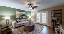 This single-story residence offers two bedrooms and two full bathrooms across a thoughtfully designed floor plan. The living room serves as the heart of the home, featuring wood-style flooring, a ceiling fan, and a bold green accent wall. French doors flood the space with natural light while providing direct access to an outdoor area. Adjacent to the living room, the dining area carries the same rich green accent wall, creating a cohesive and intimate atmosphere ideal for entertaining.

The galley-style kitchen is outfitted with dark espresso cabinetry, white quartz countertops, stainless steel appliances, and a deep double sink—offering both functionality and style. Both bathrooms mirror each other in design, each showcasing an extended vanity with light wood cabinetry, white quartz countertops, a large mirror, and wood-style flooring.

The two bedrooms feature plush carpeting, ceiling fans, and natural light from windows with blinds. Each bedroom provides ample closet space. A dedicated laundry area includes a full-sized washer and dryer alongside shelving for storage, adding everyday convenience throughout.