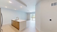 Located at 2330 Union St in Fort Myers, FL, this well-appointed 2-bedroom, 1-bathroom unit offers a clean, modern aesthetic throughout its single-floor layout. Light-toned flooring flows seamlessly across the space, complementing the bright white walls and creating a fresh, airy ambiance.

The kitchen is a standout feature, showcasing floor-to-ceiling white shaker cabinetry with gold hardware, a large center island with an undermount sink and gold faucet, stainless steel appliances including a full-size refrigerator, range, and microwave, a beverage cooler, and a tasteful tile backsplash. Recessed lighting illuminates the space effectively.

The spacious primary bedroom includes a ceiling fan, ample natural light from a window with blinds, and direct access to a well-organized walk-in closet outfitted with built-in shelving and hanging rods. The second bedroom is bright and versatile, offering light-filled simplicity and a ceiling fan with sliding glass doors leading to a private balcony overlooking the pool and palm-lined courtyard.

The bathroom is elegantly finished with large-format tile, a frameless glass walk-in shower, gold fixtures and grab bar, and a white vanity — conveying a spa-like quality. The unit's overall design is cohesive, modern, and move-in ready.
