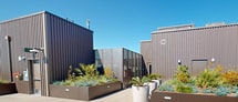 This rooftop space at 1212 Maryland St in San Francisco offers a stunning urban oasis with breathtaking panoramic views. The expansive terrace is characterized by its sleek, modern design, featuring large-format concrete tiles that create a seamless, open feel. Strategic landscaping includes raised planters filled with drought-resistant succulents and native plants, adding natural beauty and texture to the space.

The terrace is bordered by a glass and metal railing system, ensuring safety while maximizing the unobstructed views of the San Francisco Bay, city skyline, and surrounding hills. Multiple seating areas are thoughtfully arranged, providing ample space for relaxation and social gatherings. The industrial-chic aesthetic is emphasized by the presence of a large, corrugated metal structure, which likely houses mechanical equipment while serving as an architectural focal point.

Amenities appear to include built-in lighting for evening enjoyment, and there may be additional features such as outdoor heating elements or a communal grilling area, though these are not visible in the provided images. The rooftop's design skillfully balances functionality with aesthetics, creating an inviting outdoor living space that takes full advantage of its prime urban location and spectacular views.