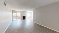 Located at 11850 Riverside Dr in the Valley Village neighborhood of Los Angeles, this single-floor unit offers a well-organized and functional layout. The open living area is generously proportioned, featuring light wood-tone flooring, neutral-toned walls, a textured ceiling, a ceiling fan, and a classic fireplace as a central focal point. Sliding glass doors lead to a private balcony, allowing natural light to fill the space. Adjacent to the living area, the kitchen is appointed with rich, dark mahogany cabinetry, a tile mosaic backsplash, stone-finish countertops, a stainless steel sink, and matching stainless appliances including a refrigerator. The bedroom features plush wall-to-wall carpeting, a window with vertical blinds for natural light, and access to a spacious walk-in closet outfitted with dual shelving systems on both sides. The bathroom includes wood-tone flooring, a dark vanity with a stone-finish countertop and undermount sink, a glass-enclosed shower, a soaking tub, and a grab bar for added convenience. Throughout the unit, a consistent neutral color palette and clean finishes create a cohesive, move-in ready atmosphere.