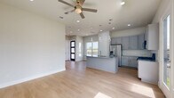 Located in Richmond, TX, this two-story home offers a thoughtfully designed layout across two floors, with the majority of living space situated on the upper level. The main floor houses a well-appointed kitchen featuring sleek gray shaker-style cabinetry, granite countertops with subtle veining, a subway tile backsplash, stainless steel appliances including a gas range and French door refrigerator, and a central island with pendant lighting — all complemented by light hardwood flooring that flows throughout the home. An attached garage with a motorized door and interior access adds everyday convenience. Upstairs, three bedrooms provide comfortable accommodations, including a spacious primary suite with a tray ceiling, ceiling fan, and private access to a closet and bathroom. The secondary bedrooms are bright and airy, with large windows offering open views of the surrounding landscape. Three full bathrooms serve the home, including one featuring full-height tile surround in the tub-shower combination with built-in niches. Neutral wall tones, recessed lighting, and clean architectural lines give the home a fresh, modern aesthetic throughout.