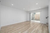 Located in Redondo Beach, California, this thoughtfully updated 2-bedroom, 1-bathroom multi-level home offers a clean, modern aesthetic throughout. Light wood-look flooring flows seamlessly across all levels, complementing the crisp white walls and recessed lighting that create a bright, airy atmosphere.

The main level features an open-concept kitchen and living area. The galley-style kitchen is outfitted with slate-blue cabinetry, matte black hardware, quartz countertops, a deep black undermount sink with a matte black faucet, stainless steel appliances, and a dedicated range hood — combining style and functionality. A sliding glass door connects the living area to a private outdoor space.

The bathroom is elegantly finished with a marble-look quartz vanity, matte black fixtures, a rectangular wall mirror with a black frame, and a tub surround clad in large-format marble-style tile with a built-in niche.

The two bedrooms are generously proportioned, each with light flooring and window treatments. One bedroom features charming exposed beam ceilings painted white, adding architectural character, while the primary bedroom offers ample space for comfortable furnishing.

A standout feature is the rooftop deck, finished in smooth white stucco and offering open-air views of surrounding palm trees and the Southern California skyline — an ideal outdoor retreat.
