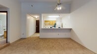 Located at 1114 Third St NE in Minneapolis, MN, this single-floor unit offers a functional and well-organized layout designed for comfortable everyday living. The galley-style kitchen is a standout feature, showcasing warm honey-toned wood cabinetry, white appliances including a range, refrigerator, and dishwasher, along with light-colored countertops and durable hardwood-style flooring. A pass-through counter opens the kitchen to the main living area, creating an open and connected feel. The living area is generously sized, featuring soft carpeting underfoot, a ceiling fan with integrated lighting, and multiple windows fitted with blinds that allow natural light to fill the room. Baseboard heating runs along the perimeter, ensuring year-round comfort. The layout also includes a hallway leading to additional storage and closet space. The full bathroom is clean and efficiently designed, offering a tub/shower combination with a decorative curtain, toilet, and a vanity with an integrated sink, all set against neutral tiling and light walls. Throughout the unit, the neutral color palette and straightforward design provide a versatile backdrop well-suited for a variety of furnishing styles.