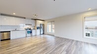 Located at 8035 Boulevard St-Laurent in Brossard, QC, this modern single-floor unit offers three bedrooms and one bathroom within a well-designed, contemporary layout. The open-concept living and kitchen area serves as the heart of the home, featuring light wood-style flooring, recessed lighting, and large windows that invite natural light. The kitchen is outfitted with sleek, high-gloss white cabinetry, a full suite of stainless steel appliances including a French door refrigerator, electric range, built-in microwave, and dishwasher, all complemented by a clean white tile backsplash. The spacious living area extends to a balcony through sliding glass doors, offering outdoor views. The three bedrooms are accessed via a bright, well-lit hallway and feature the same wood-style flooring. The primary bedroom includes a large sliding frosted-glass closet, while another bedroom benefits from a generous window with exterior views. The bathroom is finished with large-format white wall tiles, a combined tub and glass-enclosed shower, a floating wood-toned vanity with a wide mirror, and tile flooring. A dedicated in-unit laundry area with built-in shelving completes this functional and contemporary space.