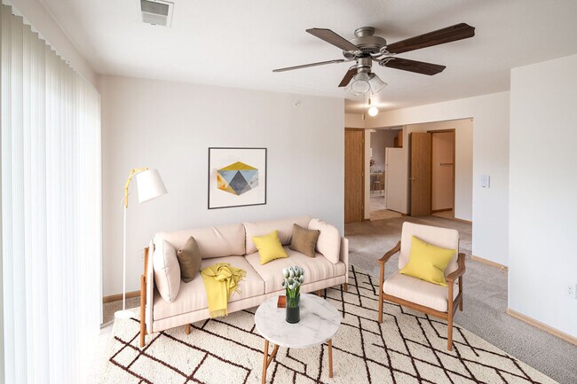 Espacio habitable elegante con persianas verticales y ventilador de techo - Highland Meadows