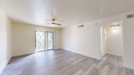 Located in Mesa, AZ, this single-floor, 3-bedroom, 2-bathroom unit offers a clean and modern living environment with consistent wood-look plank flooring and neutral warm tones throughout. The open-concept kitchen is a standout feature, boasting white shaker-style cabinetry, white quartz countertops, a peninsula island with a sink, stainless steel appliances including a refrigerator, microwave, and range, a subway tile backsplash, and stylish pendant lighting — ideal for both cooking and casual dining. The living room is bright and airy, featuring a ceiling fan with light, a diamond-patterned glass sliding door that lets in natural light and provides outdoor access, and ample open space. Each of the three bedrooms is outfitted with its own ceiling fan and wood-look flooring. The primary bedroom includes mirrored sliding closet doors, adding depth to the room. A secondary bedroom features a window with blinds for natural light and privacy. Both bathrooms are finished in white with tub-shower combinations, white vanity cabinetry, and matching flooring. A hallway connects the bedrooms and bathrooms, with additional storage accessible off the kitchen. The overall ambiance is bright, clean, and move-in ready.