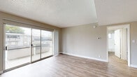 This single-floor residence in Vallejo, California offers a clean, functional layout designed for comfortable everyday living. The main living area greets you upon entry with warm light wood-style flooring, neutral beige walls, and a textured ceiling. Large sliding glass doors flood the space with natural light and open to a private balcony with views of the surrounding neighborhood, creating a seamless indoor-outdoor connection.

The kitchen is thoughtfully updated with crisp white shaker cabinets, stone-look quartz countertops, a stainless steel electric range with overhead ventilation, and ample storage throughout. A pass-through opening connects the kitchen to the main living space, enhancing the open feel of the floor plan.

Two bedrooms offer a quieter retreat, each finished with plush neutral carpeting, soft wall tones, and textured ceilings. Natural light filters through windows with vertical blinds, and each room provides a comfortable, versatile space.

The bathroom is finished with light wood-style flooring, a white vanity with brushed nickel hardware, a tiled shower-tub combination, and a small window for ventilation. The overall palette throughout the residence is cohesive and neutral, lending a bright, move-in-ready ambiance well-suited to the Northern California lifestyle.